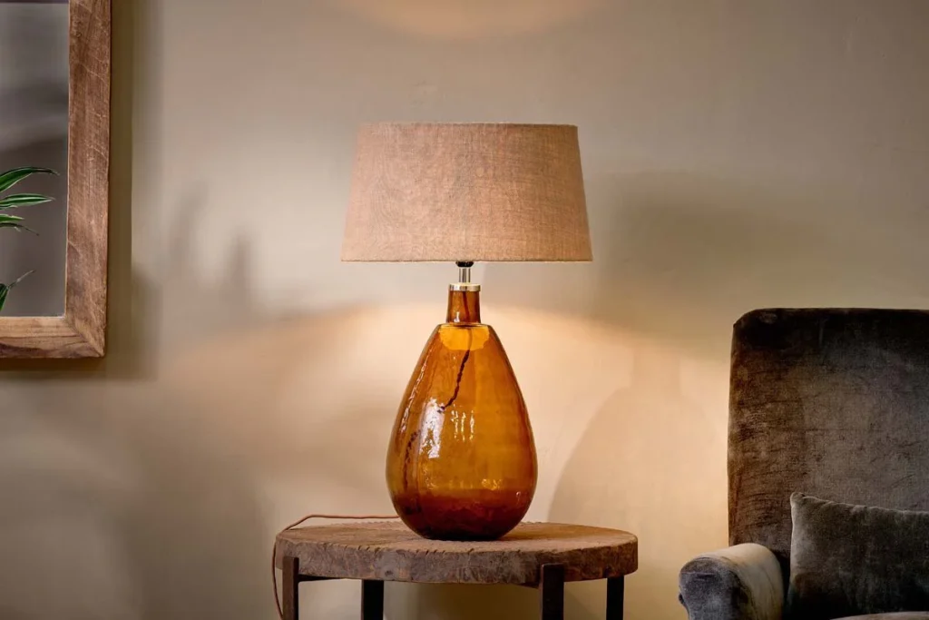 recycled glass tall lamp in an amber colour with a neutral linen lampshade