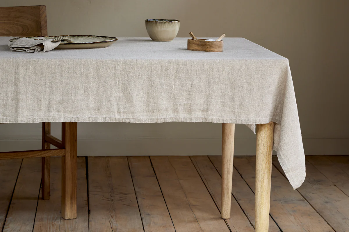 The Honest Nkuku Recycled Glassware Review: We Look At 10 Tumblers, Highballs and Gin Glasses linen tablecloth on a wooden table with a ceramic bowl on top of it and a smaller wooden bowl