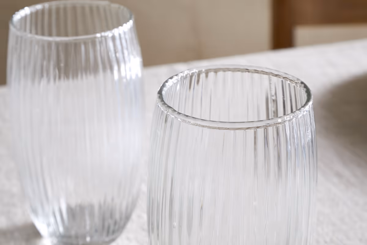 The Honest Nkuku Recycled Glassware Review: We Look At 10 Tumblers, Highballs and Gin Glasses a close up shot of a ridged clear glass tumbler made from recycled glass