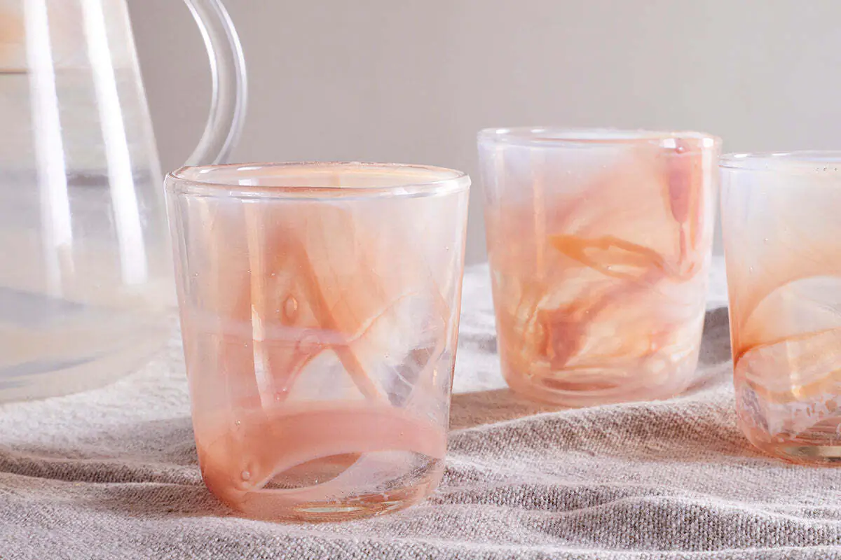 The Honest Nkuku Recycled Glassware Review: We Look At 10 Tumblers, Highballs and Gin Glasses marble swirl tumbler glasses in an apricot colour