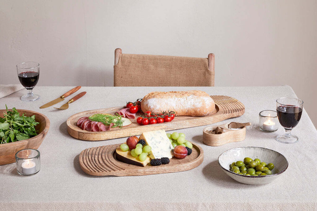 The Honest Nkuku Recycled Glassware Review: We Look At 10 Tumblers, Highballs and Gin Glasses mango wood serving board with charcuterie and bread and cheese on top