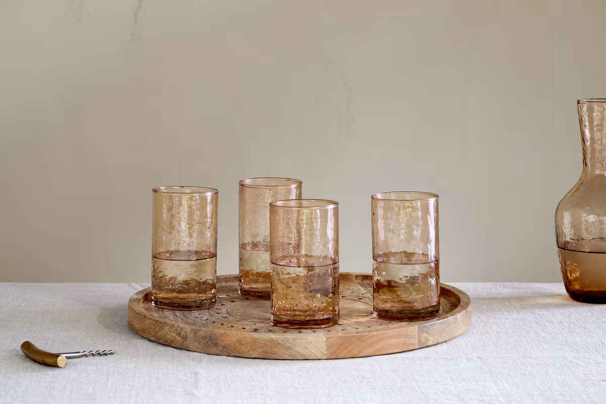 The Honest Nkuku Recycled Glassware Review: We Look At 10 Tumblers, Highballs and Gin Glasses four dusty terracotta highball tumblers in a hammered pattern