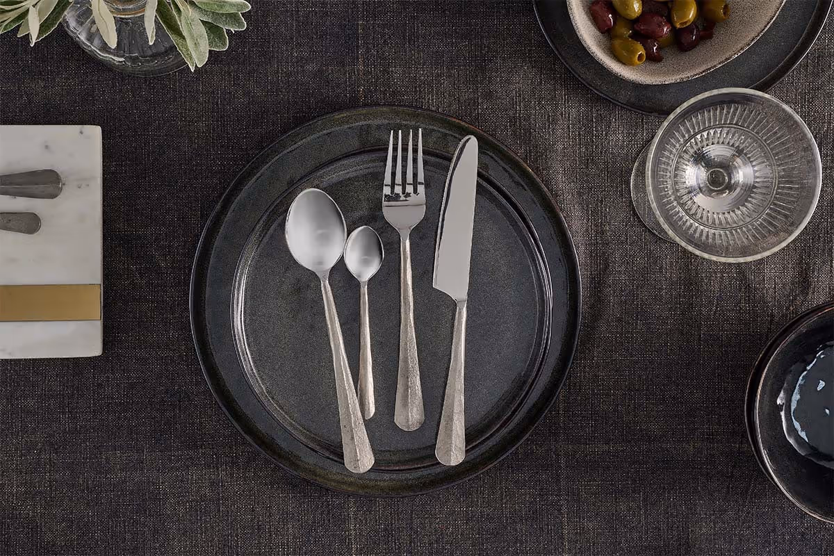 The Honest Nkuku Recycled Glassware Review: We Look At 10 Tumblers, Highballs and Gin Glasses brushed silver cutlery set on a black plate