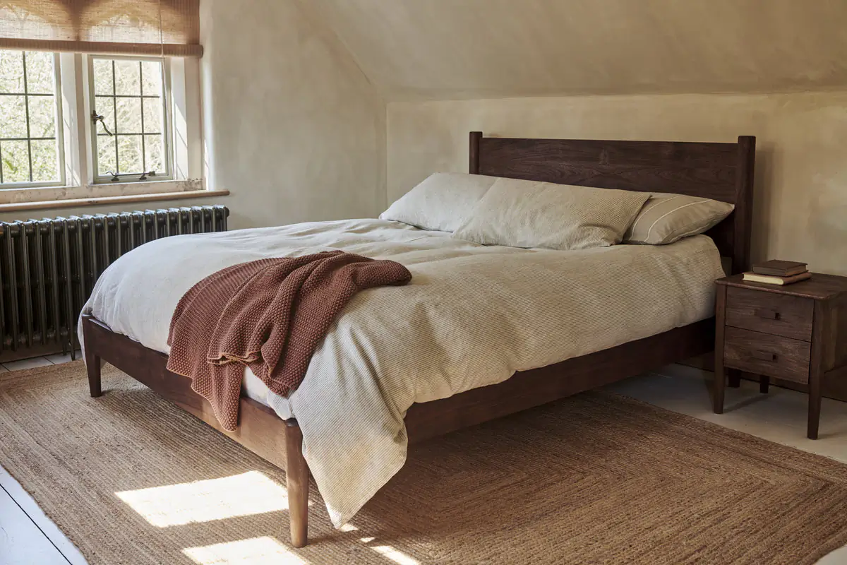 How to Create a Sustainable Bedroom: A Practical Guide The anbu bed by Nkuku in a washed walnut finish made from acacia wood.