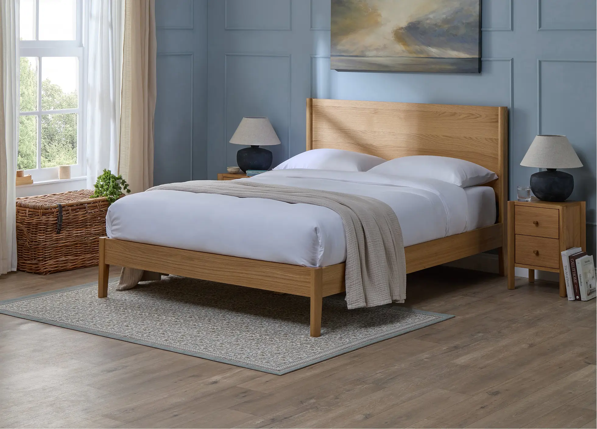 How to Create a Sustainable Bedroom: A Practical Guide the Epping bedframe from Simba Sleep styled in a calming bedroom with light blue walls, a picture above the bedframe and a lamp on a bedside table.