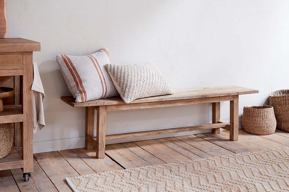 Reclaimed wood bench with two cushions.