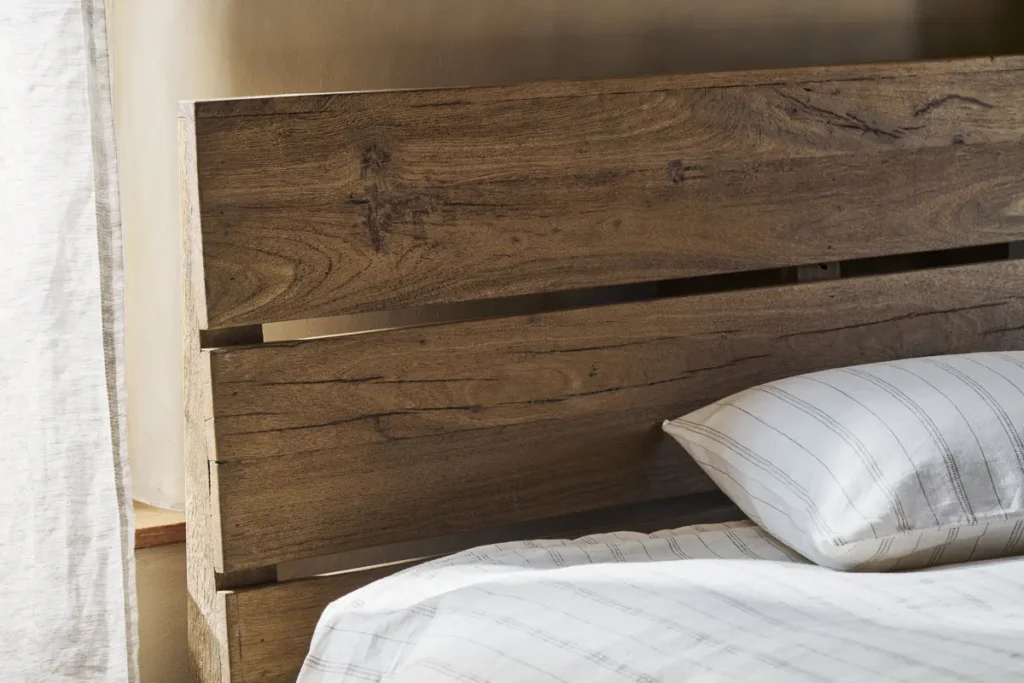 How to Create a Sustainable Bedroom: A Practical Guide Close up of the Iya reclaimed wood bed headboard by Nkuku.