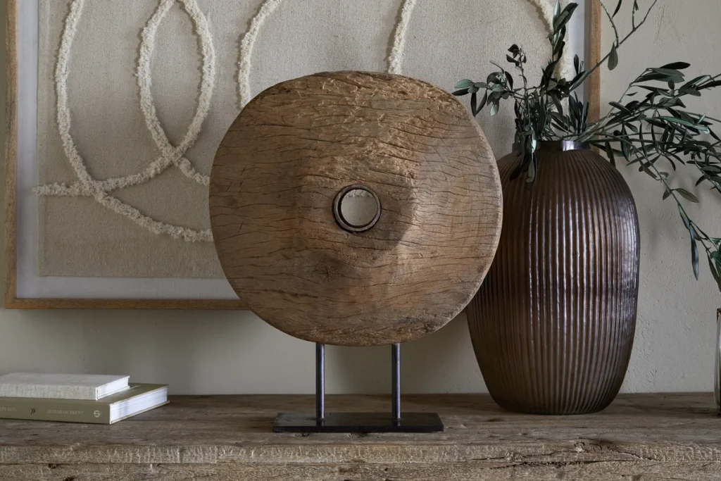 Reclaimed wood home decor item in rounded wood with metal stand.