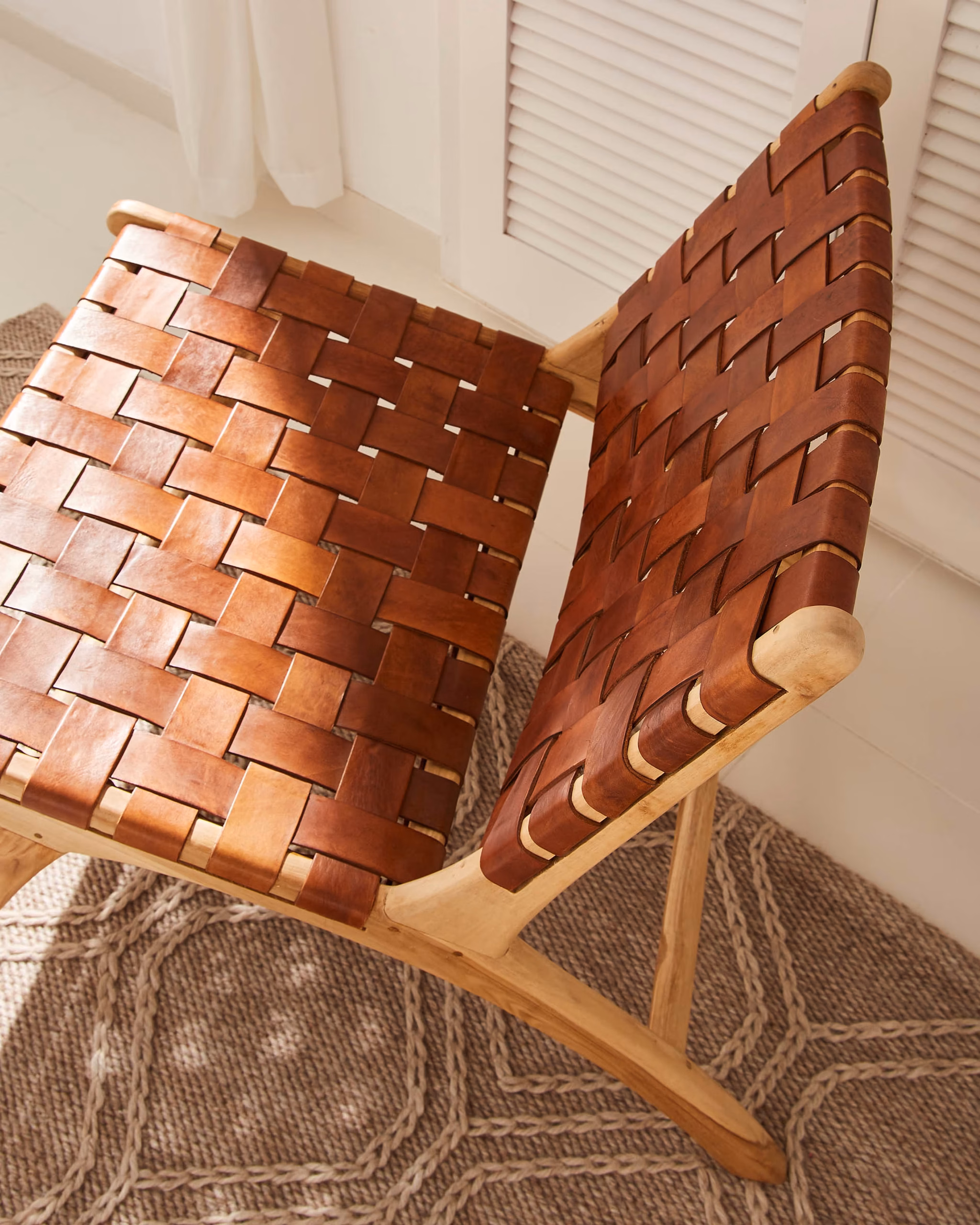 Autumn Winter Home Trends 2026: A Sustainable Edit Woven leather and solid teak wood armchair with natural oak finish to the frame.