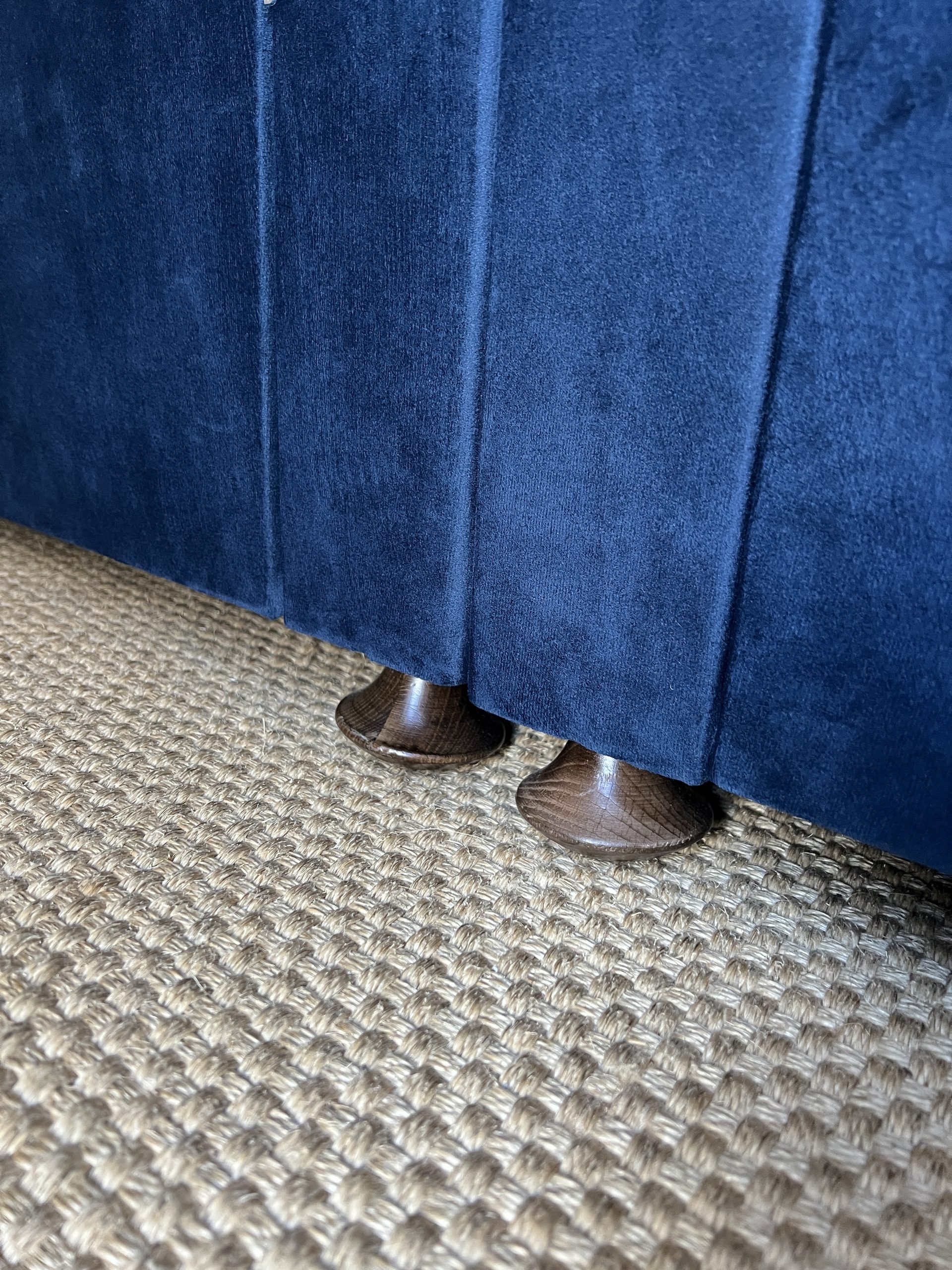 Dark wood fluted feet close up picture of the simba Sleep Jesmond bed in navy velvet.