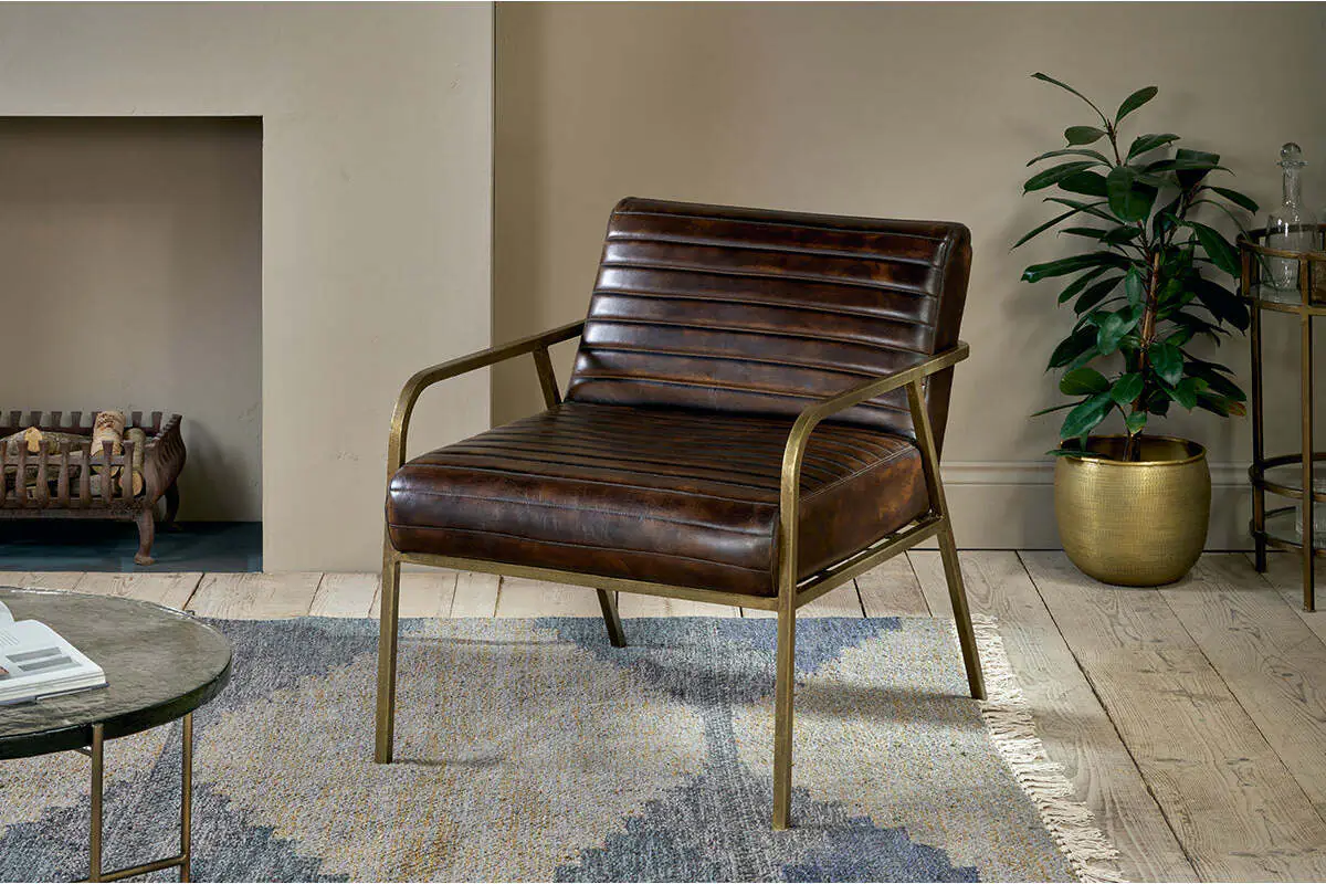 Autumn Winter Home Trends 2026: A Sustainable Edit Ribbed leather armchair in dark tan leather and antique brass frame and legs.