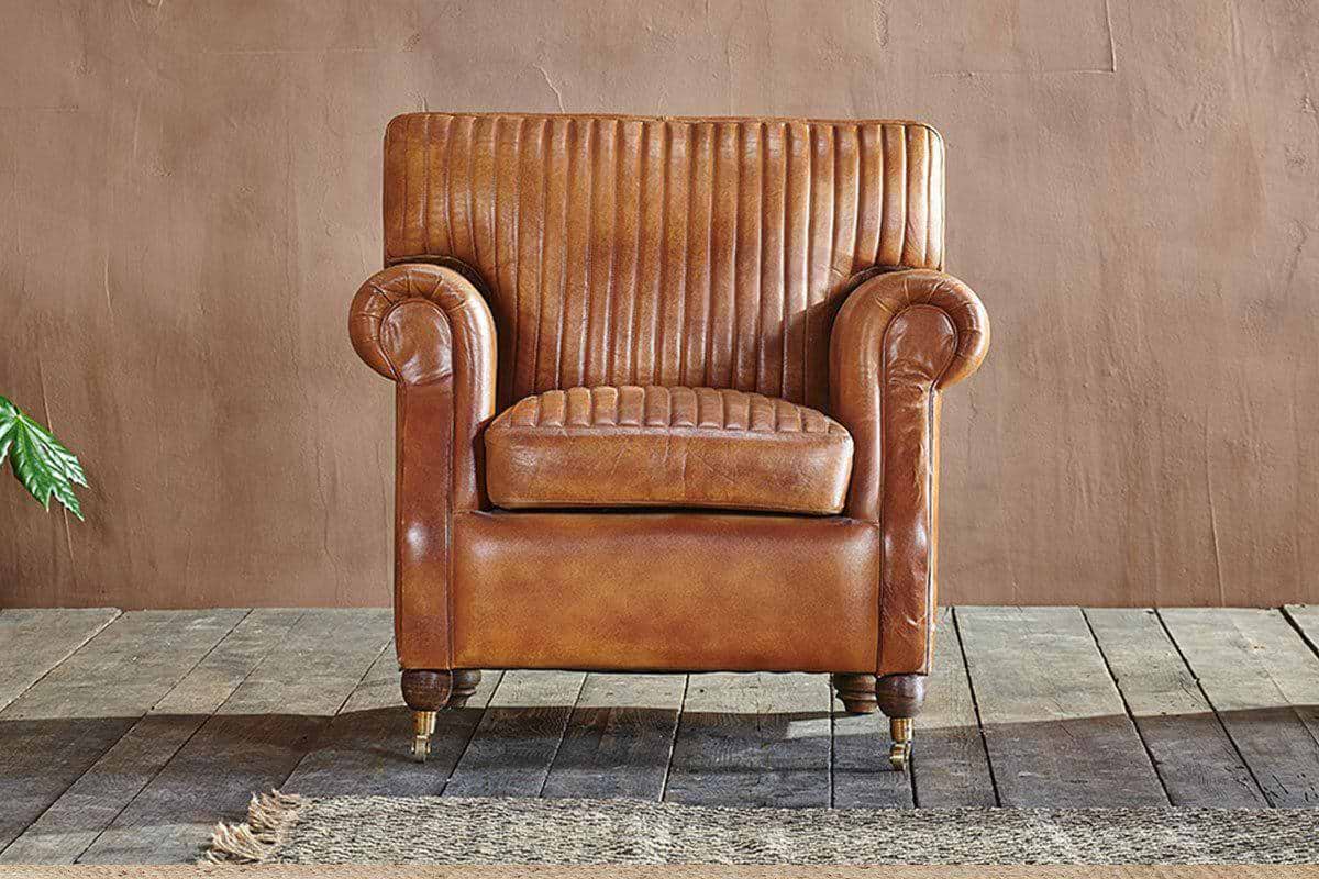 Autumn Winter Home Trends 2026: A Sustainable Edit ribbed leather armchair with antique brass feet.