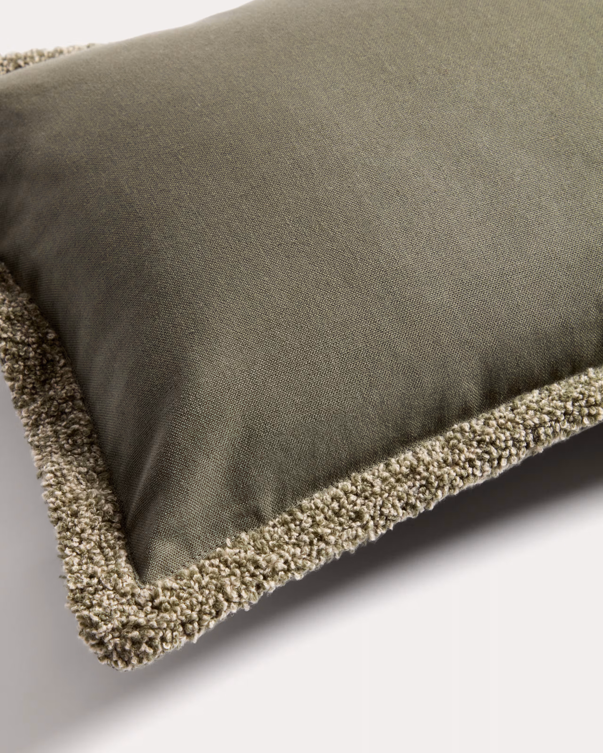 Autumn Winter Home Trends 2026: A Sustainable Edit Green cushion cover with boucle fringing in white and olive.