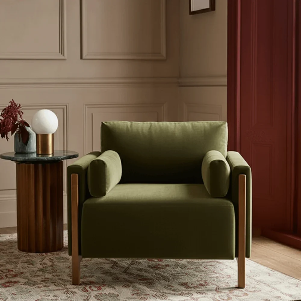 Autumn Winter Home Trends 2026: A Sustainable Edit Dark green velvet armchair with exposed wood frame.